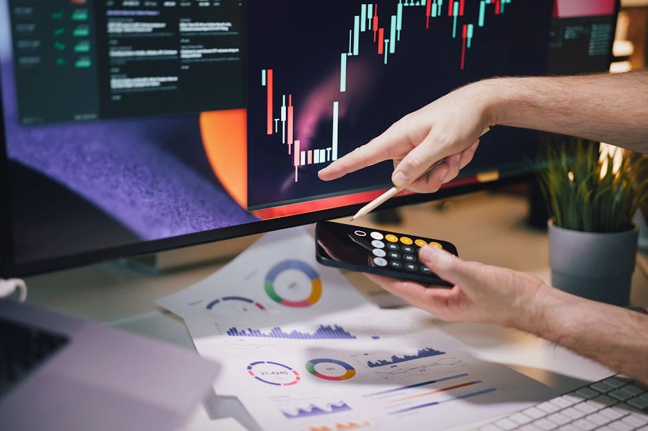 Marketingový expert analyzuje data na několika monitorech.